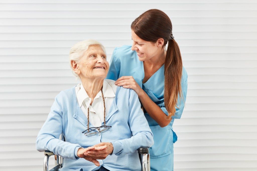 nurse and older woman smiling at each other