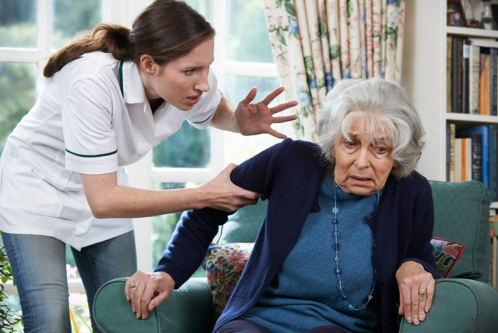 caretaker shouting at a senior woman