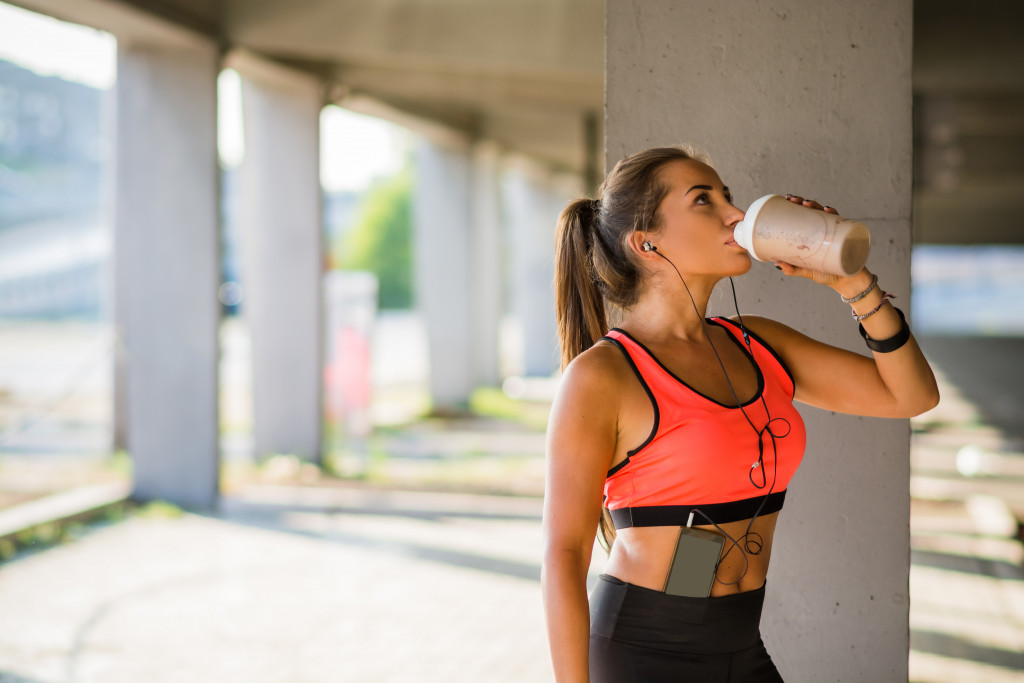 woman drinking after having a cardio workout