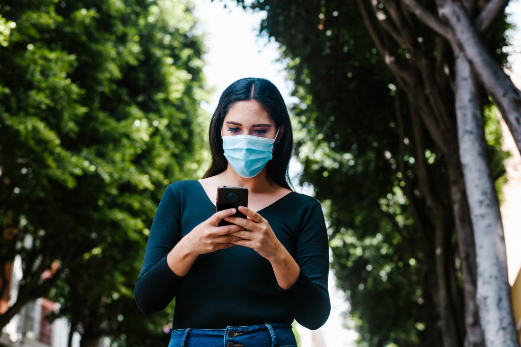 woman texting while wearing a mask