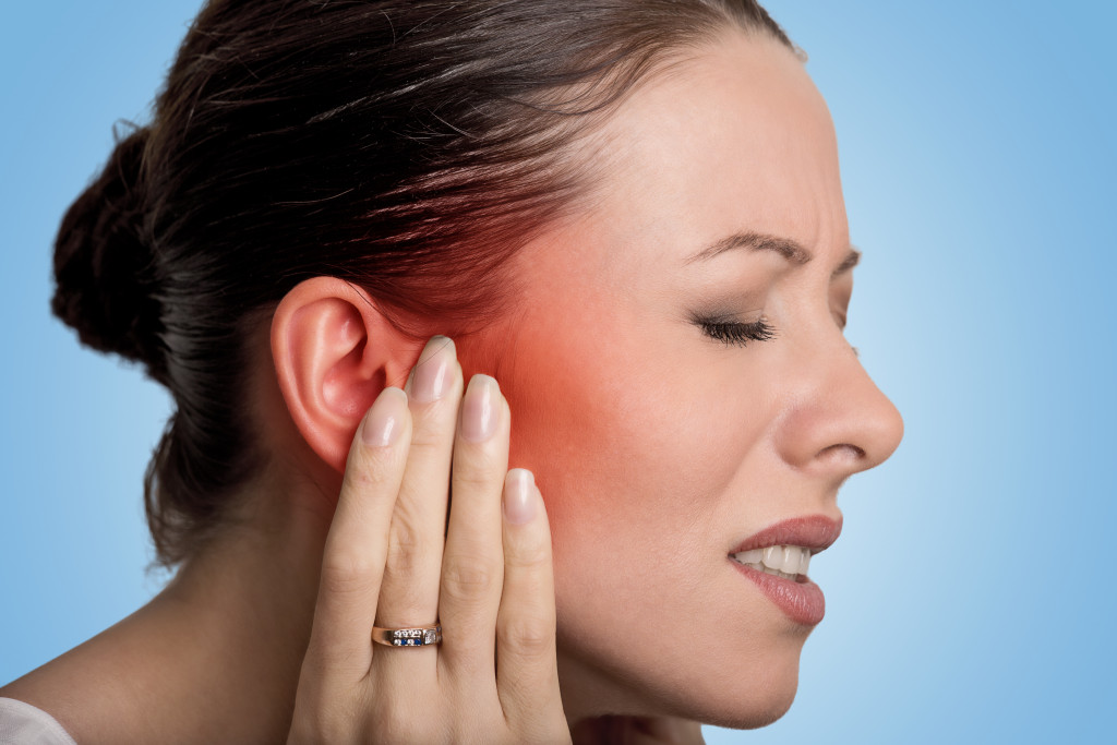 woman experiencing migraine while having hearing loss