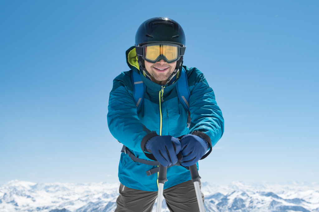 man holding skii poles standing on snow
